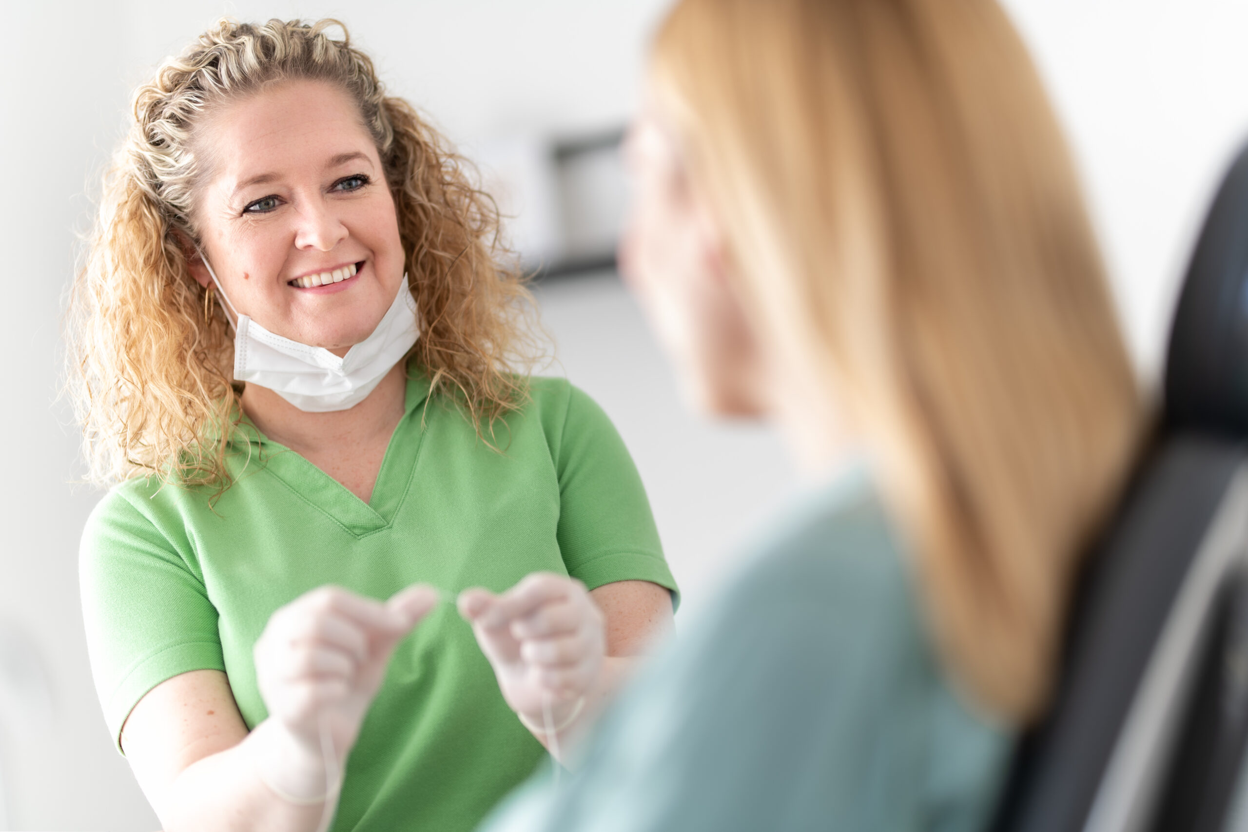 Dentalhygienikerin erklärt Zahnseideanwendung in der Praxis Dr. Schütz